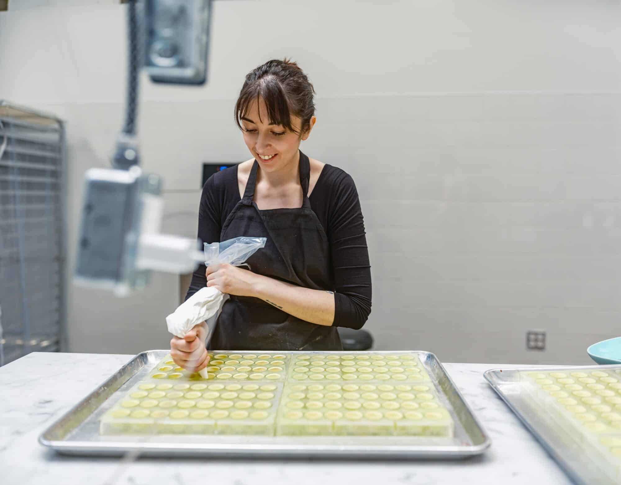 Woman using a piping bag in commercial kitchen